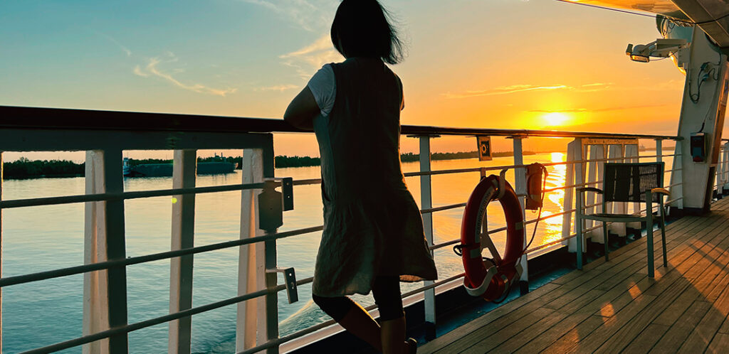 Persona admirando el atardecer, desde un barco