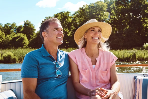 Personas sentadas en un crucero fluvial viendo en paisaje