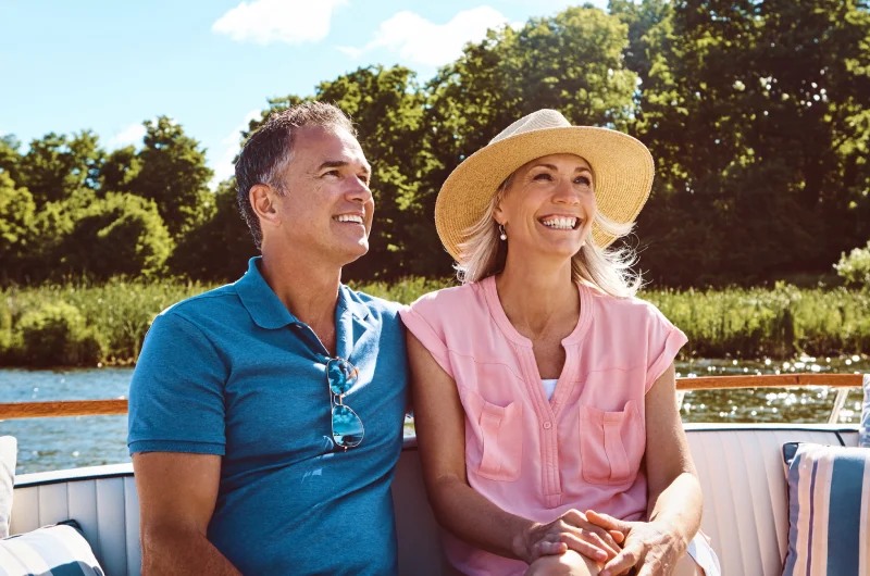 Personas sentadas en un crucero fluvial viendo en paisaje